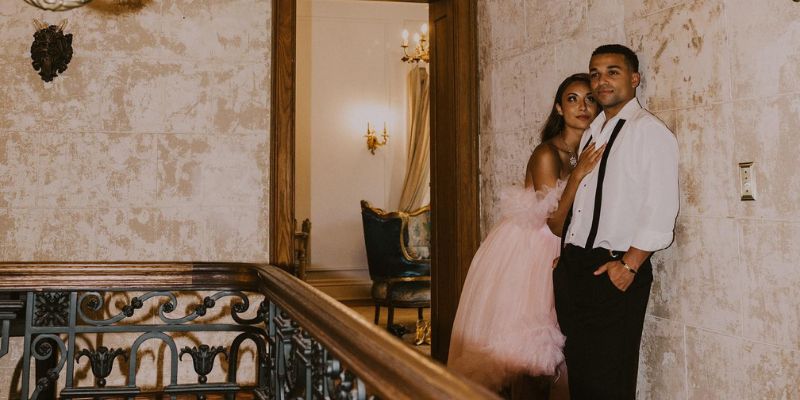 A couple wearing formalwear holding each other gazing into the distance