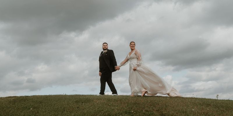 A newlywed couple walking in the breeze