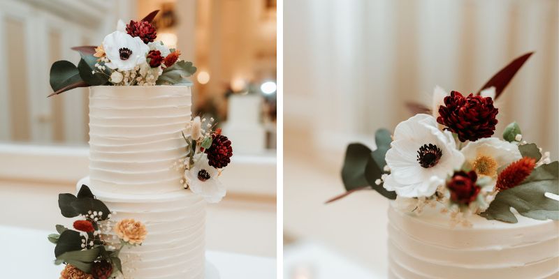 A detail shot of a wedding cake featuring red florals