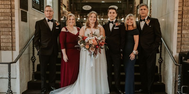 A bride and groom posing with family members