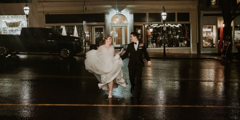 A newlywed couple walking across the street