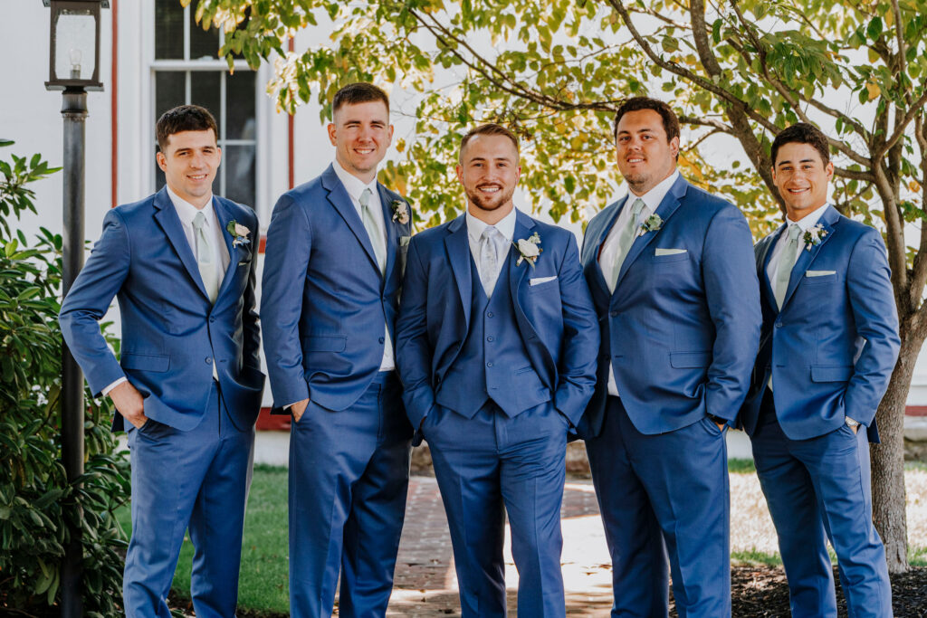 what to wear for your wedding. a group of groomsmen and the groom dressed in blue suits